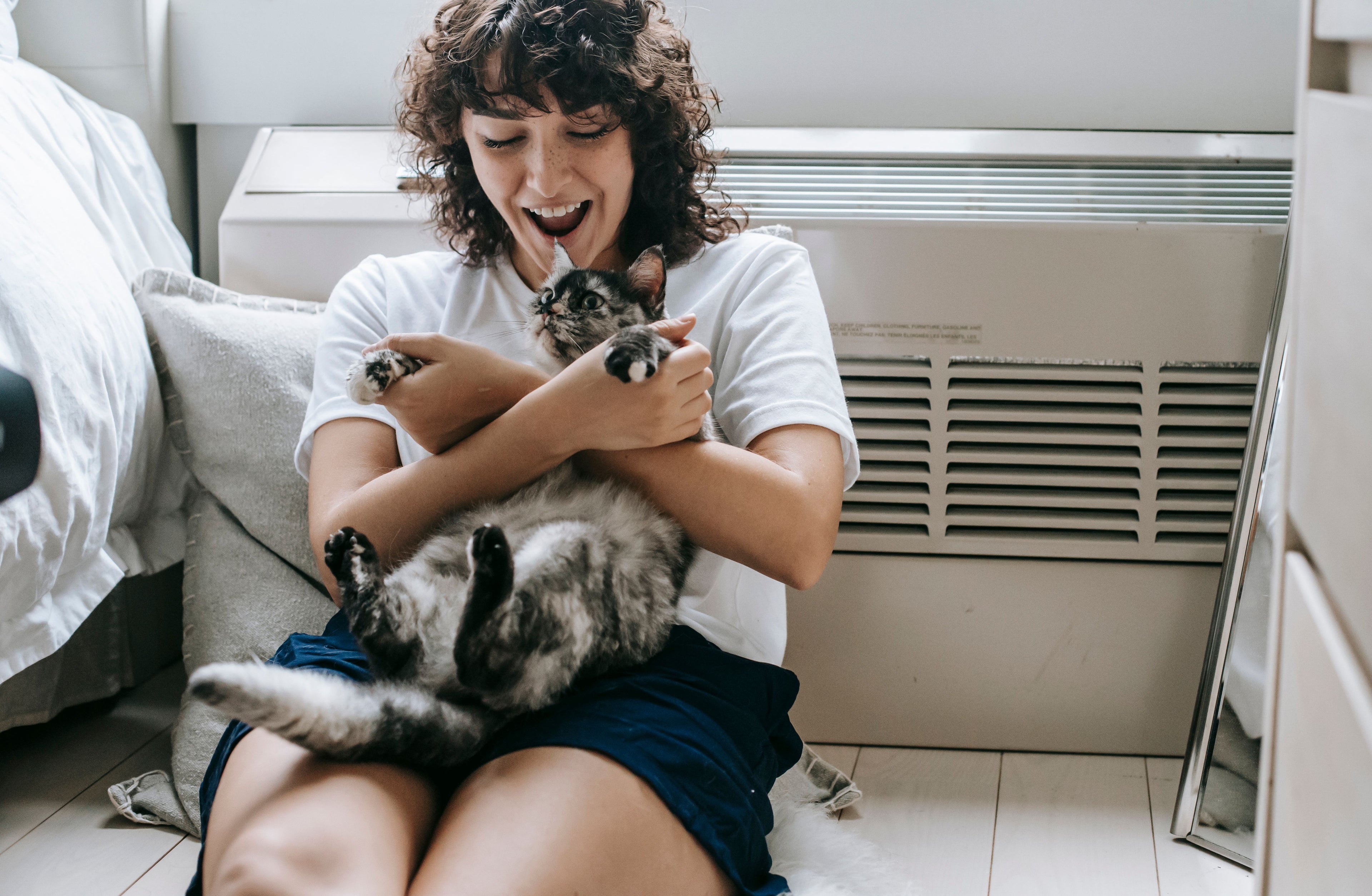 Femme souriante jouant avec son chat à la maison